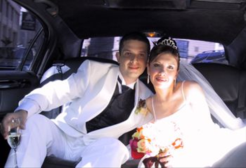 Bride & Groom in back of Lincoln Limousine