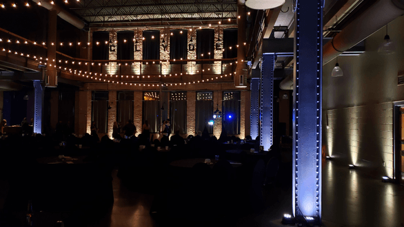 Wedding lighting at Clyde Iron Works. Up lighting in champagne on the bricks and soft white on the columns.
