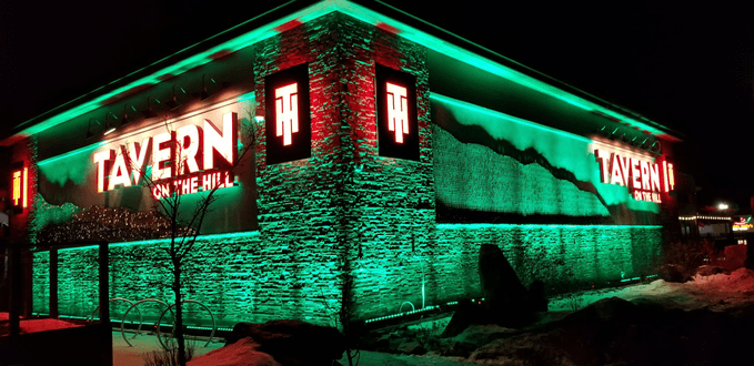 Tavern on the Hill lit with green outdoor lighting for St. Patrick's Day.