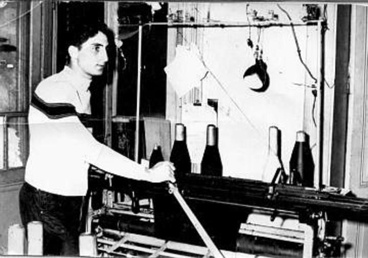 Mauricio Arenzon operating a flat textile machine in his father's factory to
maufacture jacquard knit hats and caps.