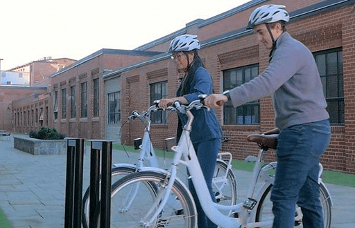 Bike share riders docking bikes to rack