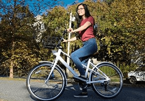 Female Bike share rider at park