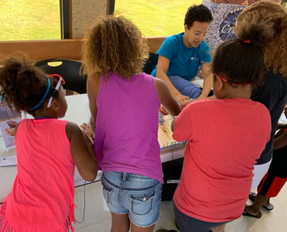 Community Engagement Manager Laurel Ryan leads children in a community art activity.