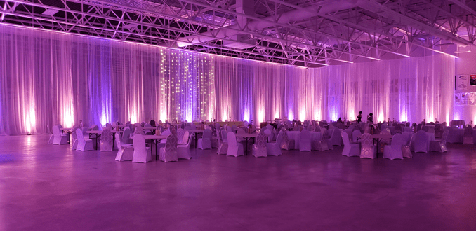 Wedding lighting at the Eveleth Curling Club with peach and blue lavender up lighting