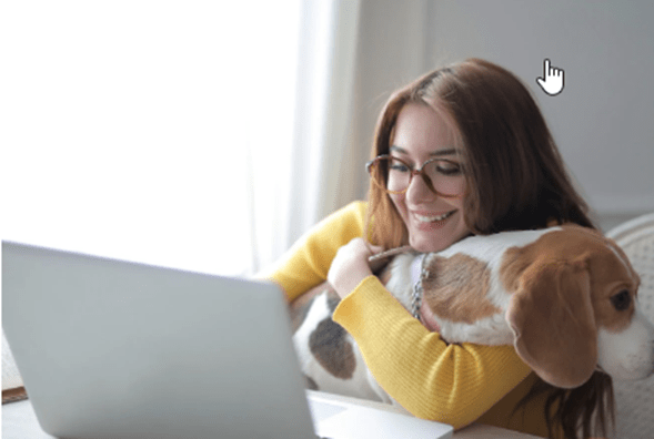 Young Woman with glasses with small dog on lap in front of computer
