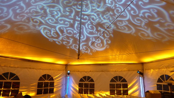 Tent wedding lighting. Up lighting in yellow with gobo patterns on the ceiling.