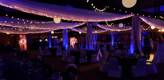 Blue up lighting with double bistro at Spirit Mt. Lighting by Duluth Event Lighting. Fabric Ceiling by The Vault.