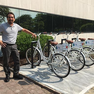 Property manager showing off bike share system at corporate office park