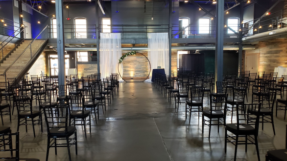 A wedding ceremony on the lower level of the Malting Building. Up lighting in a champagne color for the ceremony by Duluth Event Lighting.