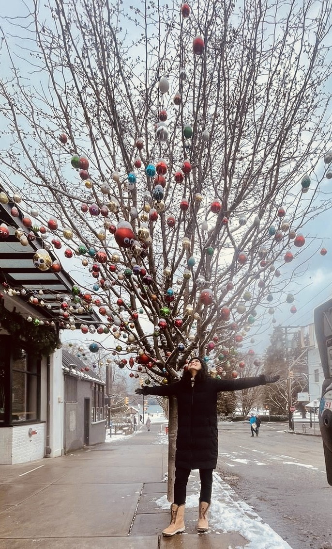 Tulip Joshi Standing Under a Tree Decorated for Christmas