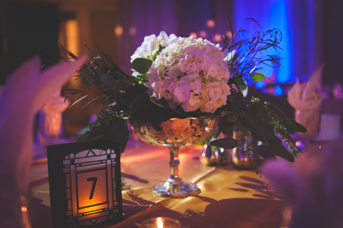 Photo by 3 Irish Girls Photography. Pinspot on flowers with blue up lighting at Greysolon Ballroom.