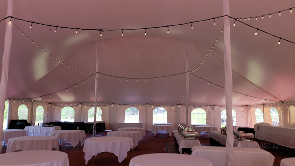 bistro lighting inside a tent for a wedding. Photo during the day