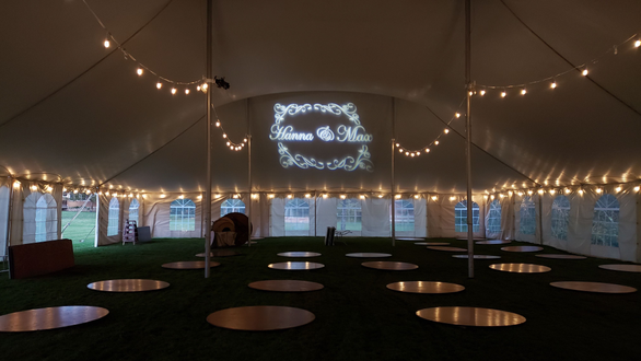 Tent wedding lighting. Bistro and a wedding monogram over the head table.