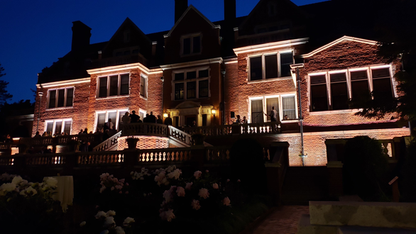The back side of Glensheen Mansion lit for a wedding in the garden.