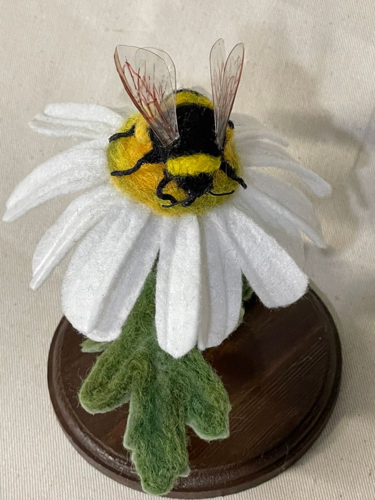 Needle felted bumblebee gathering pollen from a felted daisy.