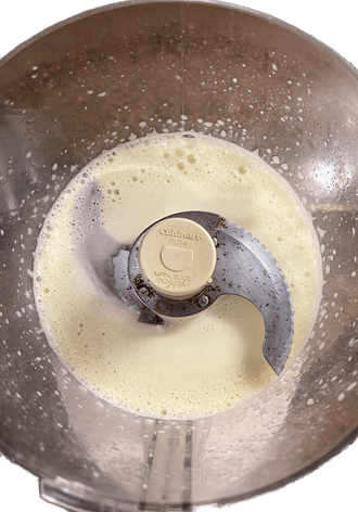 Food processor with egg and dry ingredients combined.