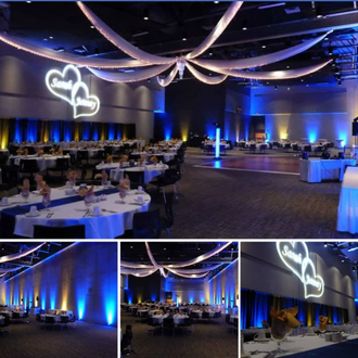 A Black Bear Casino wedding lighting with blue and yellow up lighting and a wedding monogram.
