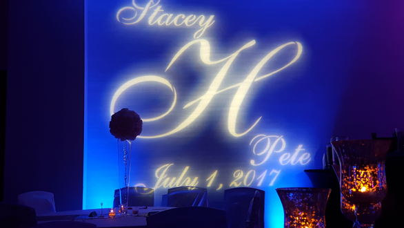 Wedding lighting at Pier B. Up lighting in blue and magenta with a wedding monogram.