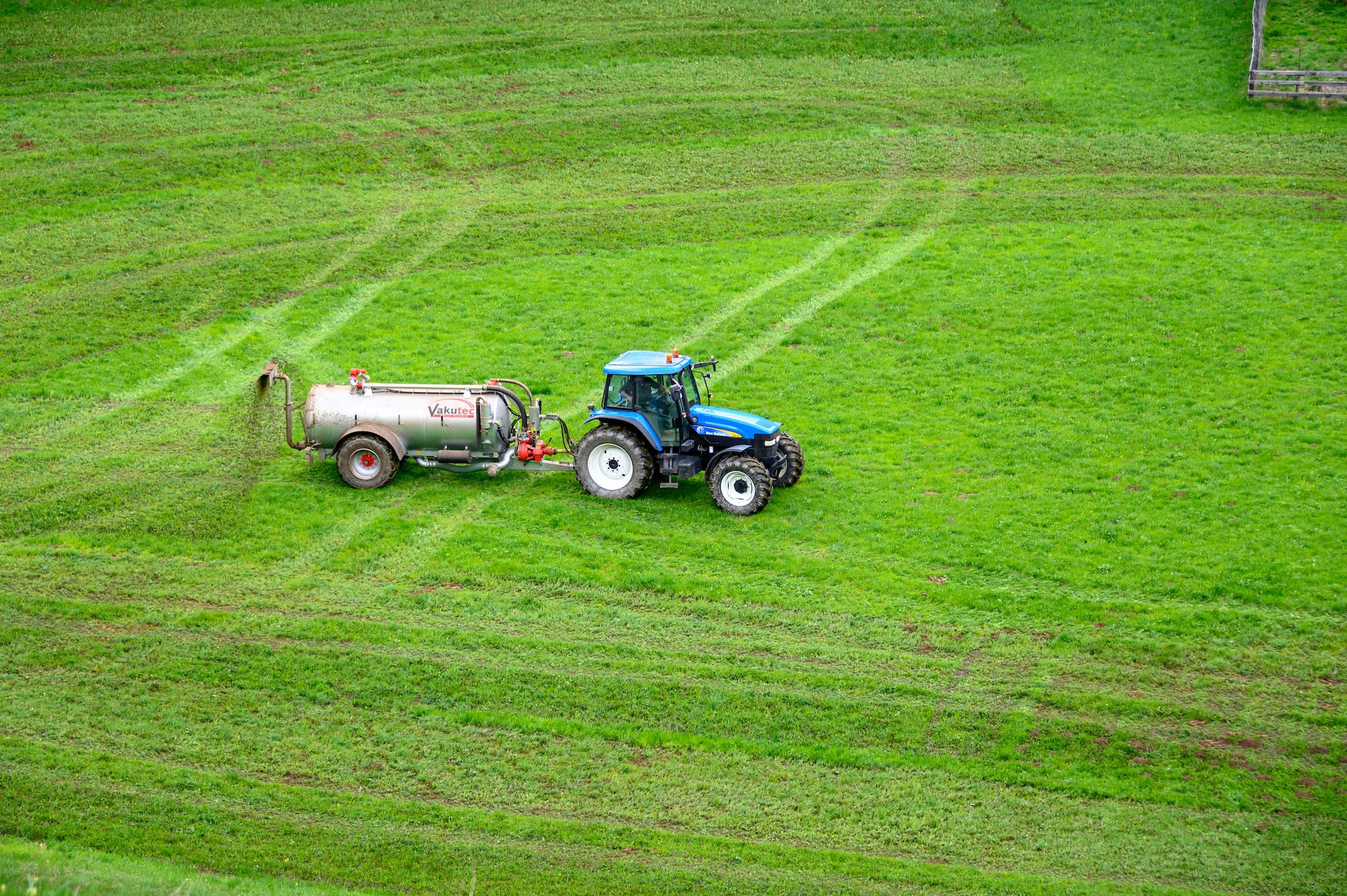 Photo of blue tractor spreading manure 