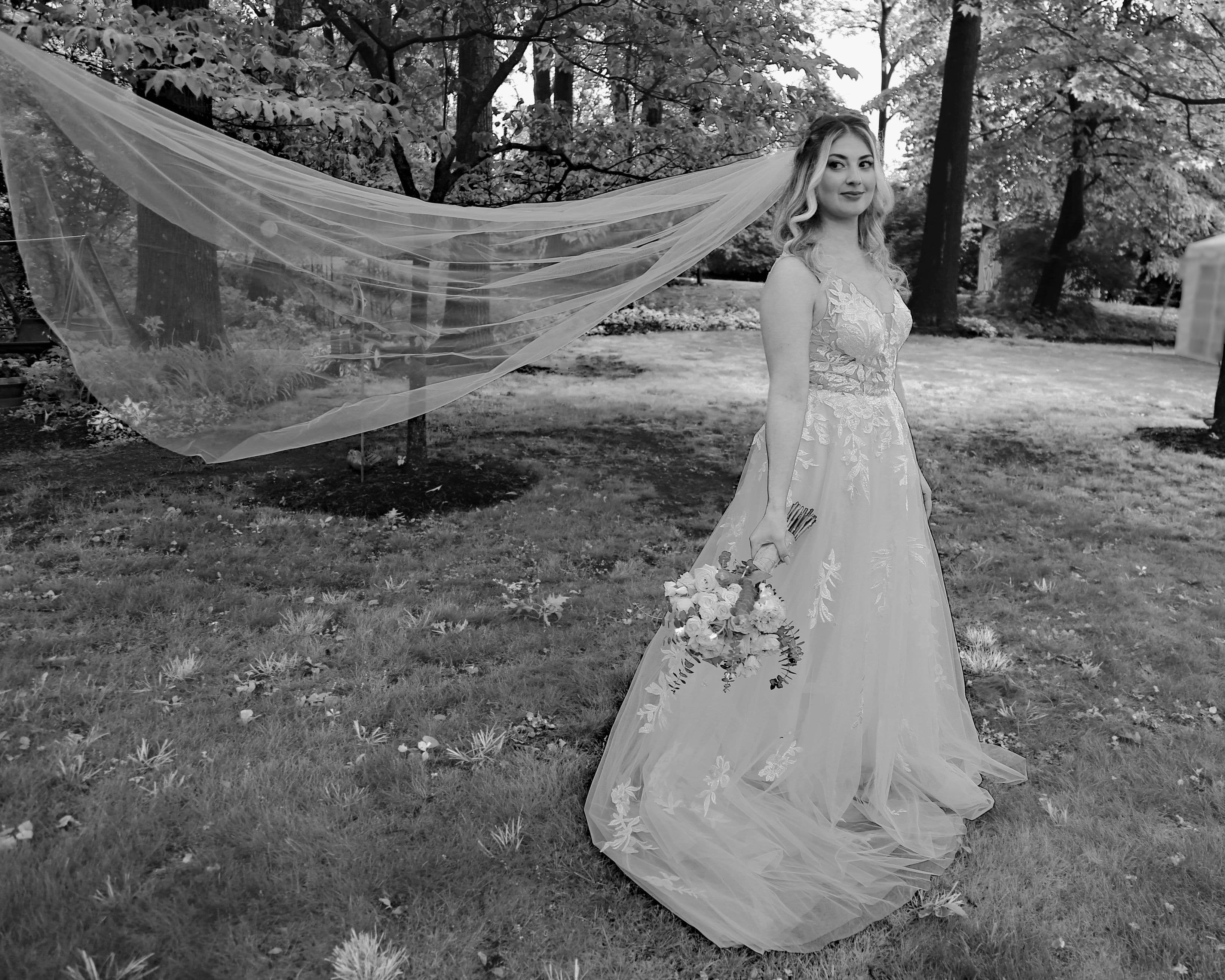 Wedding Photographers in Bucks County. Photography by Angel C at Tylerstar Productions. Black and White photo of a Bride with her Veil Flying