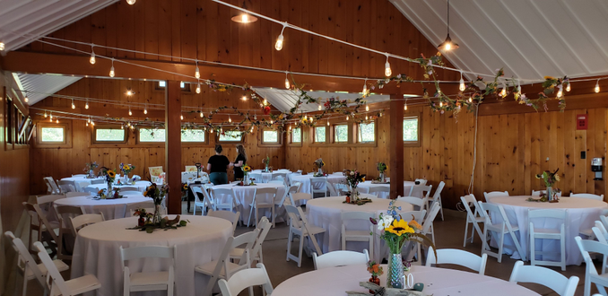 Park Point Beach House wedding with white corded bistro with flowers and greenery attached.