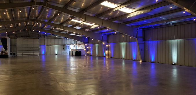 Wedding lighting at the Lake County Fairground with blue and white up lighting and bistro on the beams by Duluth Event Lighting.