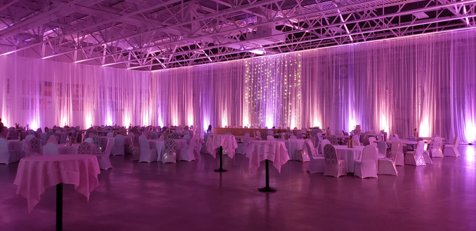 Wedding lighting at the Eveleth Curling Club with peach and lavender pink up lighting.
