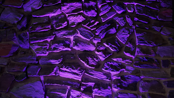 Giants Ridge wedding lighting with purple up lighting on the rock wall by Duluth Event Lighting.