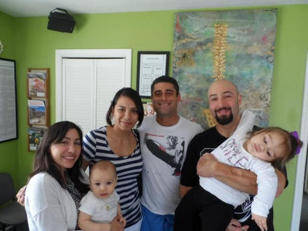 Dr. Biscotti of South Bay Family Chiropractic is performing chiropractic care for the whole family in this happy clients photo.