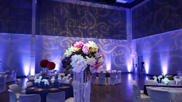 Wedding lighting at the Passion Event Center. Up lighting in lavender purple. Pin spots on flowers. Gobo pattern on walls.