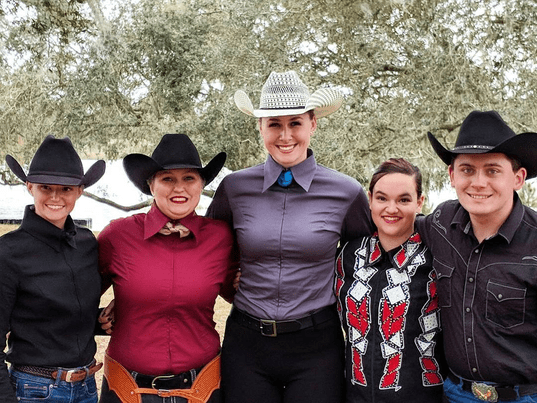 Five members of the UNF Western team standing side by side in Western show attire outside.