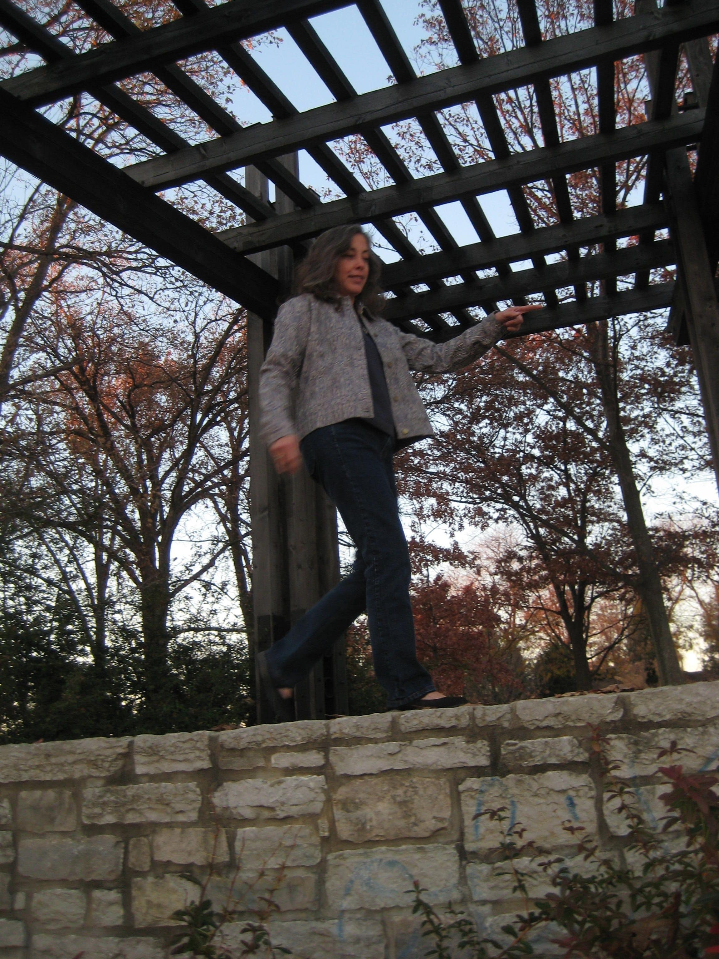 Joanne walking along the top of a brick wall