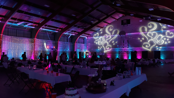Blue and magenta wedding lighting at the Cloquet Armory. Heart gobos on wall.