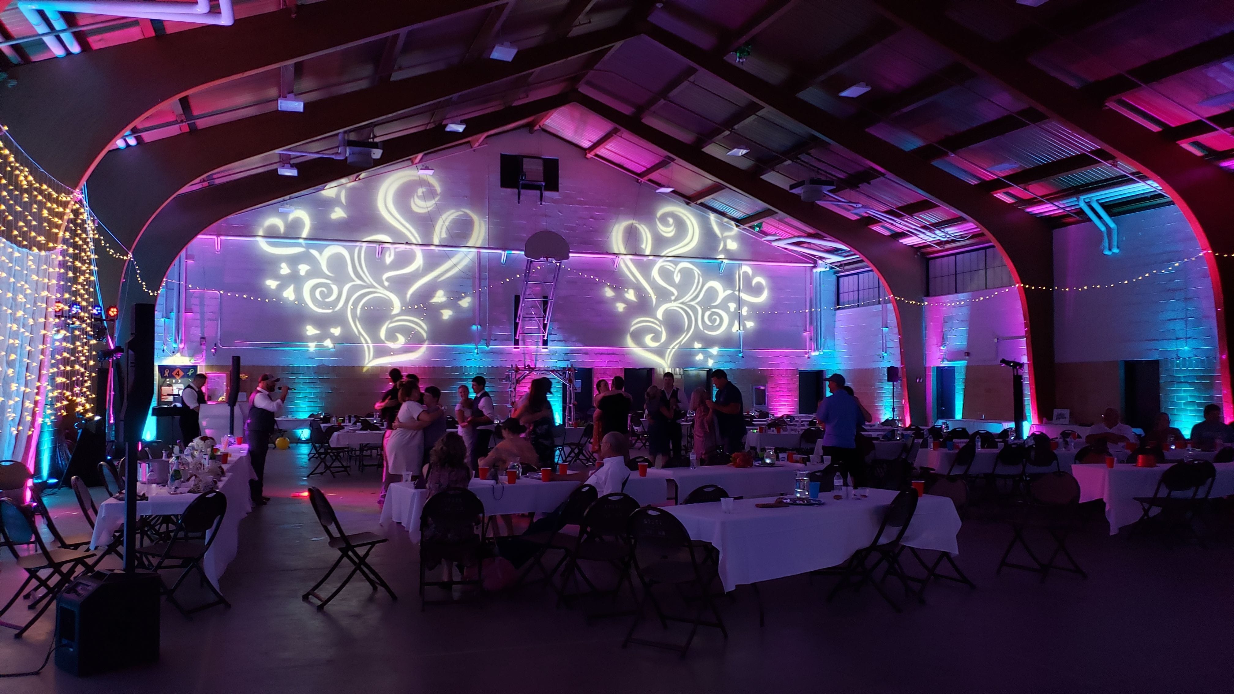 Wedding lighting at the Cloquet Armory. Up lighting in blue and magenta with heart gobos on the wall