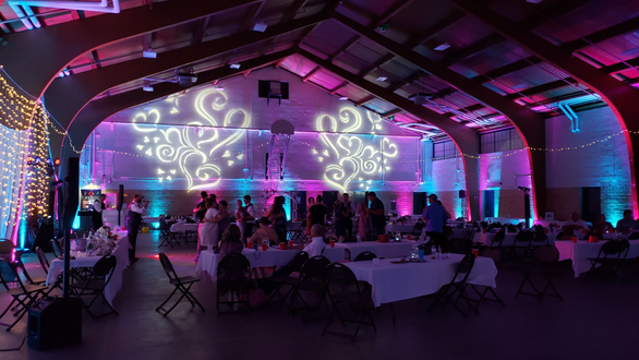 Cloquet Armory wedding. Up lighting in blue and magenta with heart gobos on the walls.