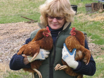 Olwen Woodier Holding 2 Chickens