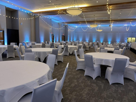 Iron Trail Motors Event Center wedding lighting in dusty blue up lighting and bistro on the ceiling by Duluth Event Lighting.