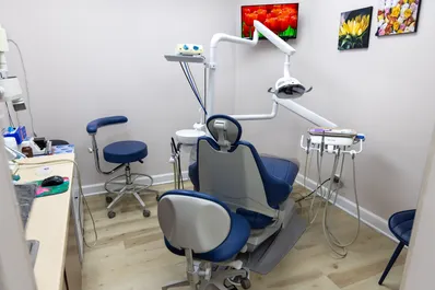 A dentist points to a dental X-ray displayed on a tablet