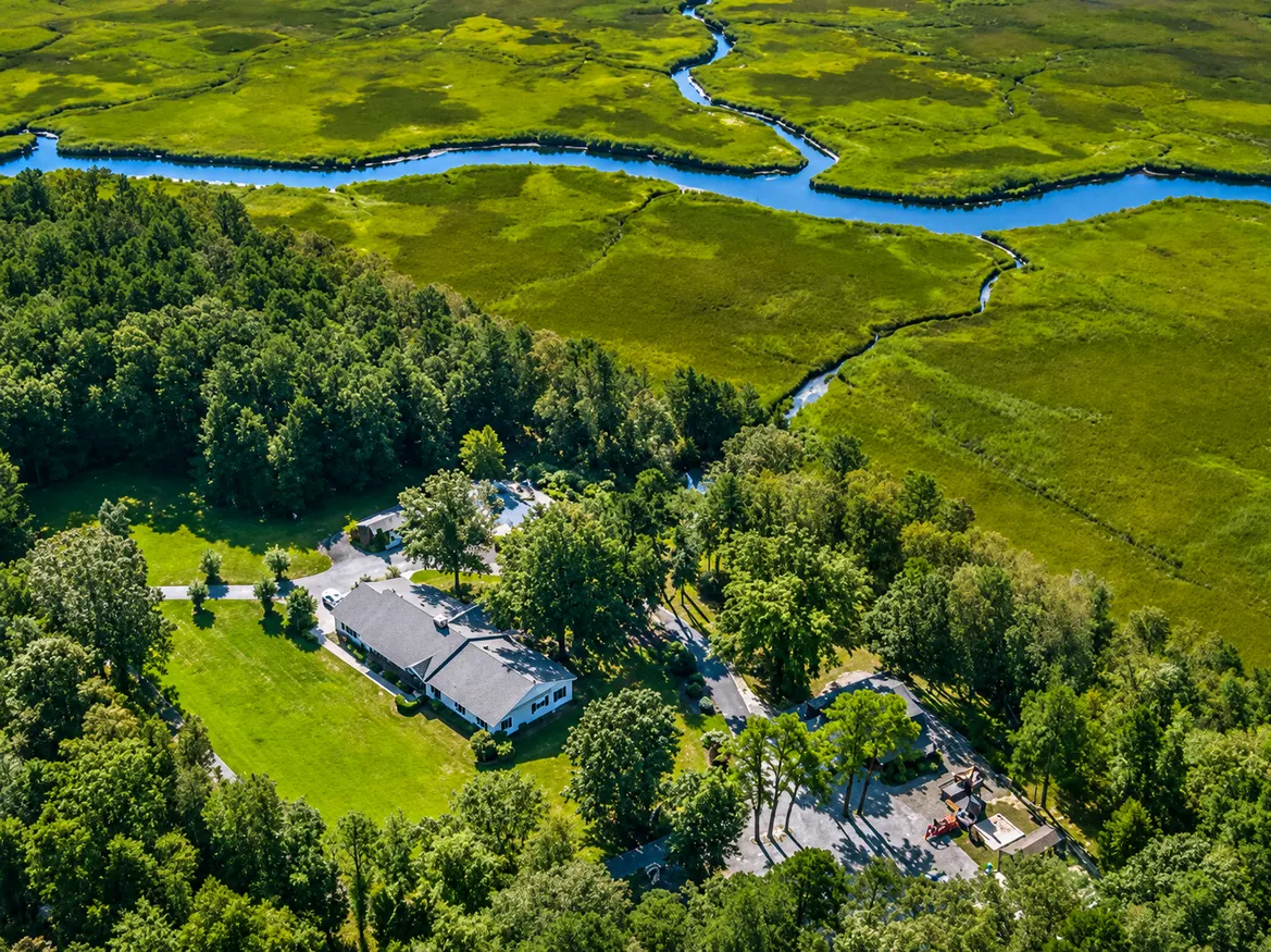 Spacious marshland estate with winding blue waterways.